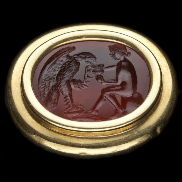 Neo classical carved cornelian intaglio, with a scene depicting Hebe feeding an eagle (Jupiter) from a cup, in an 18ct gold brooch setting c.1800