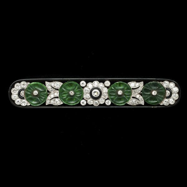 Art Deco carved jade and diamond brooch, the platinum setting decorated with black enamel, c.1930