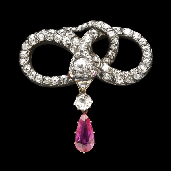 Exquisite antique diamond brooch in the form of a snake wound into a love knot, with a ruby pendant – a symbol of eternal love.