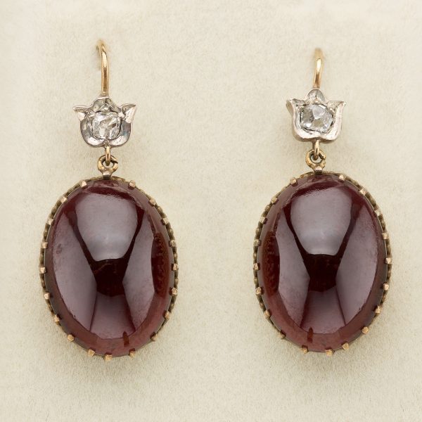 Victorian cabochon garnet earrings, the oval garnets in fine gold, claw settings are suspended from small, rose diamond mounts