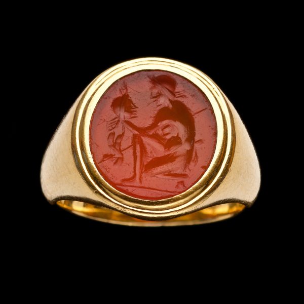 Roman cornelian intaglio depicting a warrior holding the decapitated head of his enemy, 22ct gold mount