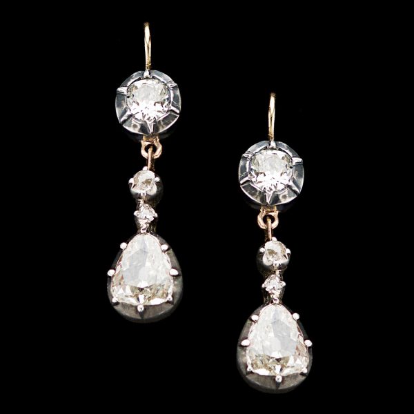 Antique diamond drop earrings, each set with a 0.50ct pear shaped diamond and an oval 0.35ct diamond, colour G-H, 18ct gold and silver settings